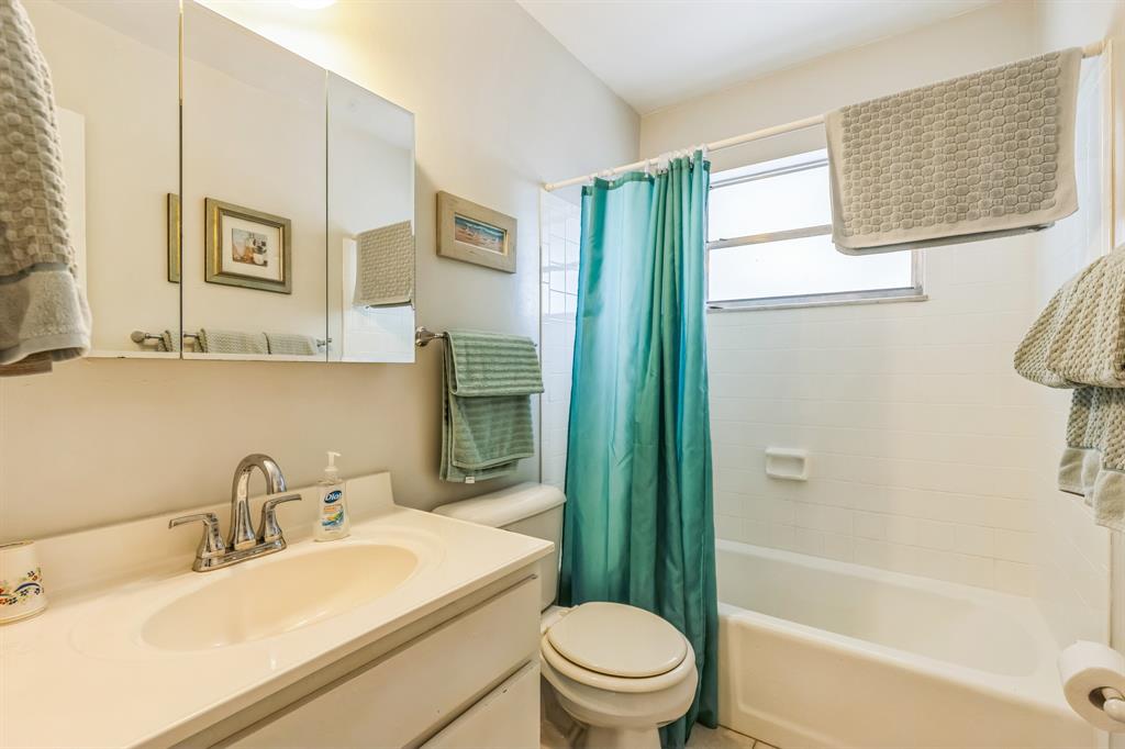 1153 Southeast Dolphin Drive Stuart, FL 34996 - Photo 21 of 31 a bathroom with a sink a toilet and shower