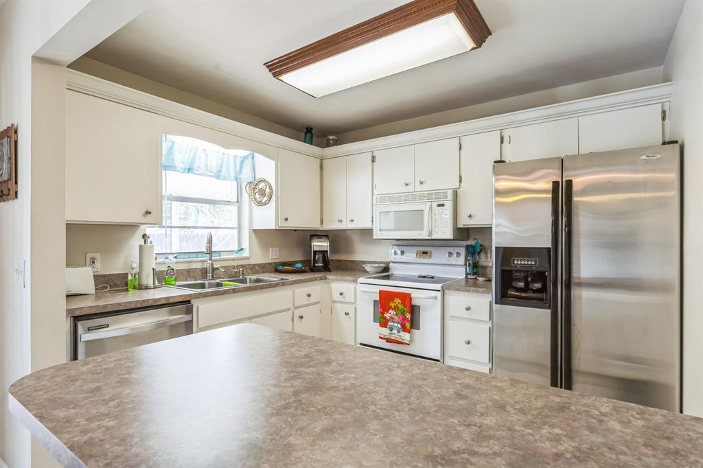 1153 Southeast Dolphin Drive Stuart, FL 34996 - Photo 10 of 31 a kitchen with stainless steel appliances granite countertop a refrigerator a stove and a sink
