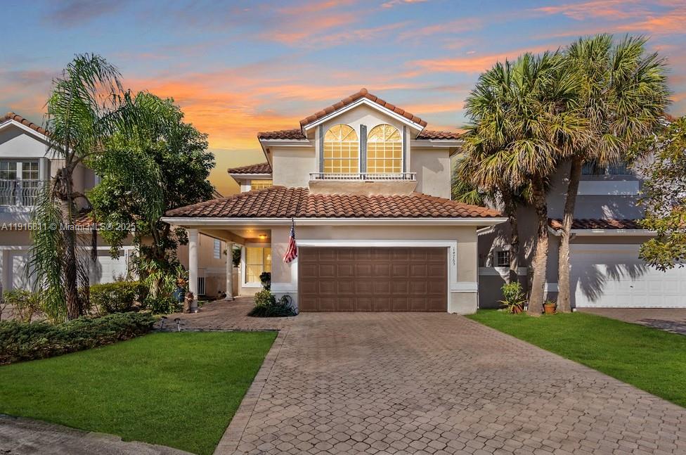 a view of a house with a yard and potted plants