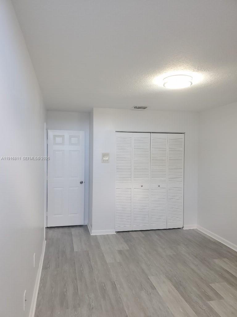 14765 Southwest 132nd Place Miami, FL 33186 - Photo 13 of 48 an empty room with wooden floor and windows