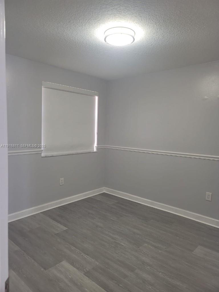 14765 Southwest 132nd Place Miami, FL 33186 - Photo 41 of 48 an empty room with wooden floor and windows