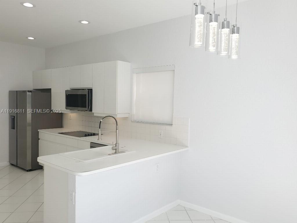 14765 Southwest 132nd Place Miami, FL 33186 - Photo 5 of 48 a close view of a sink and a microwave in a room