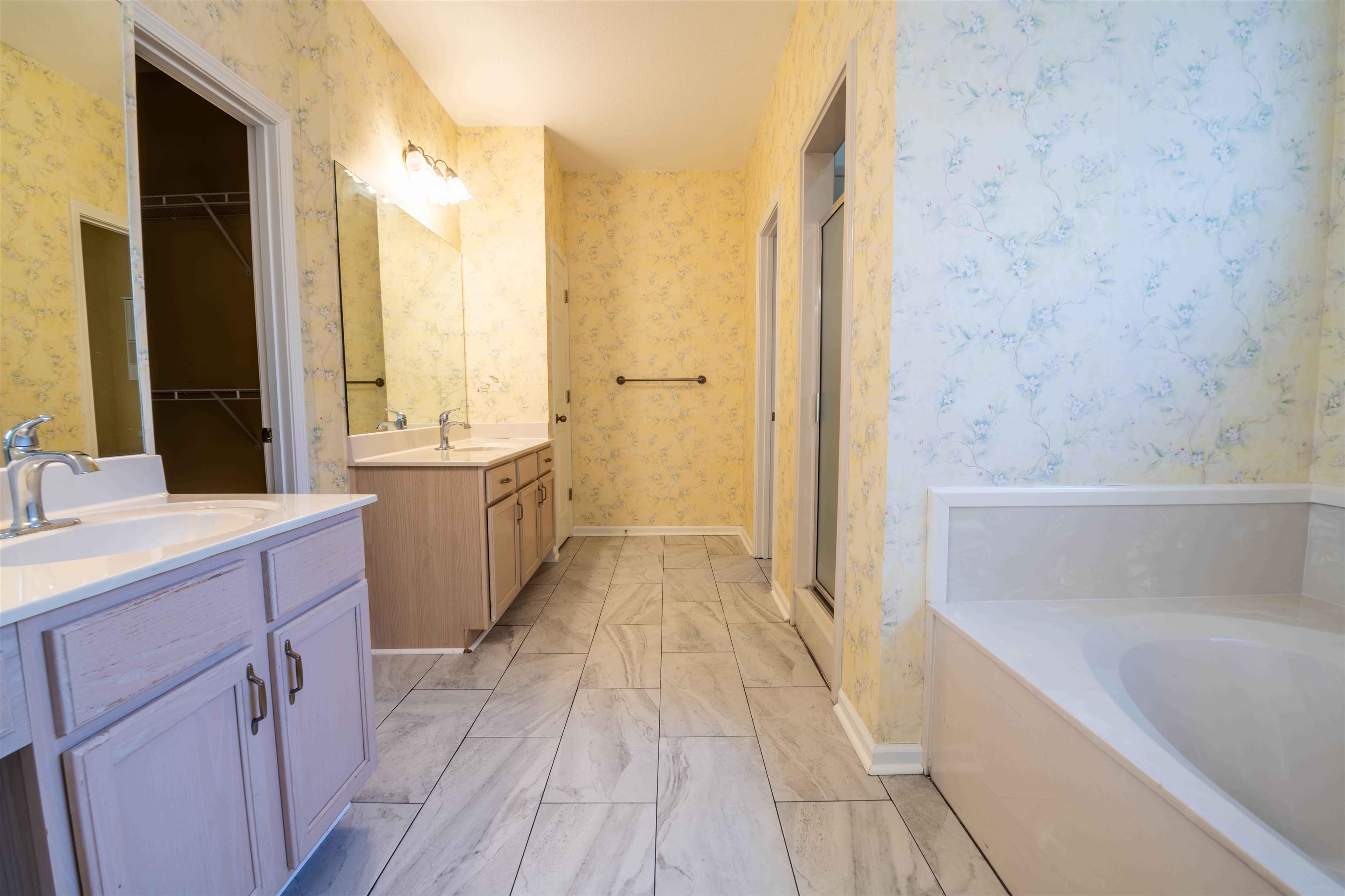 4170 Calla Drive Bartlett, TN 38135 - Photo 19 of 40 a bathroom with a double vanity sink a mirror and a bathtub