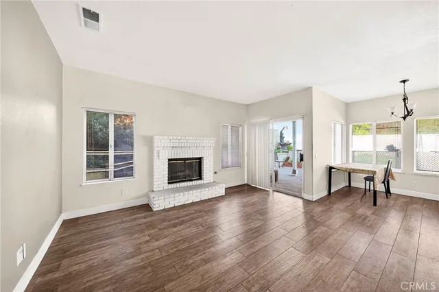 a view of a livingroom with wooden floor and a fireplace