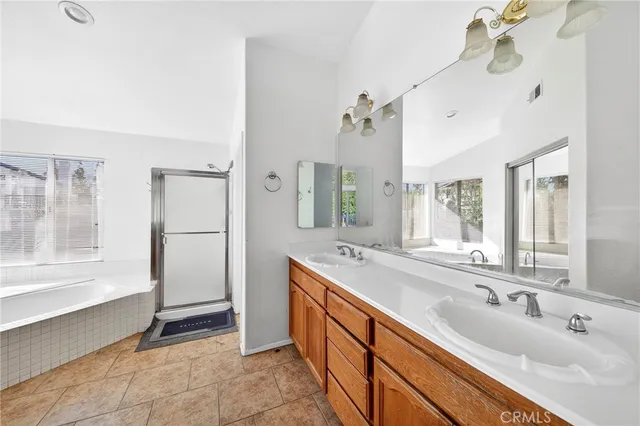 a spacious bathroom with a double vanity sink a mirror and a bathtub