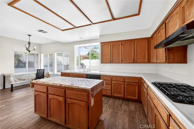 a kitchen with stainless steel appliances granite countertop wooden cabinets stove and sink
