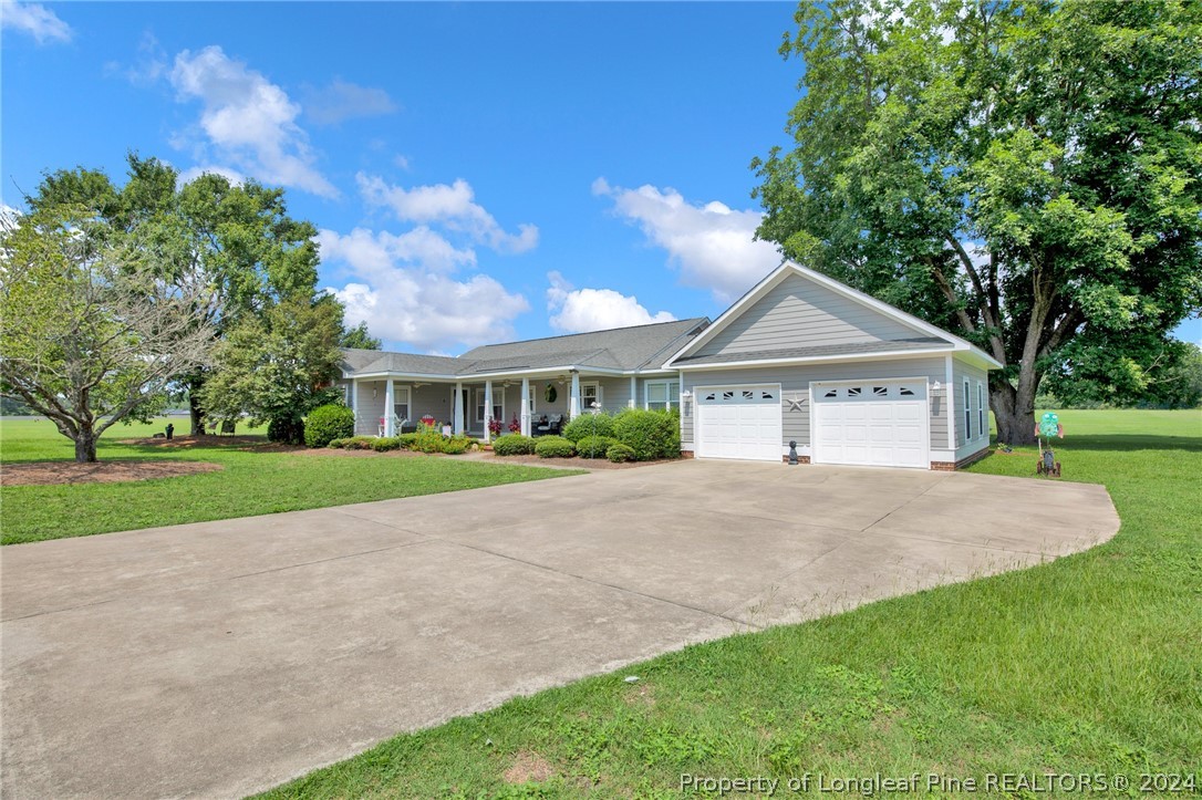 7311 Maxwell Road Stedman, NC 28391 - Photo 2 of 37 a front view of a house with a yard and garage