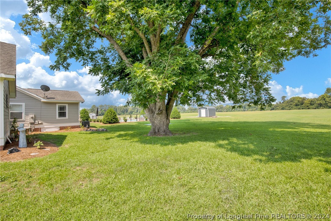 7311 Maxwell Road Stedman, NC 28391 - Photo 30 of 37 a front view of a house with garden and trees