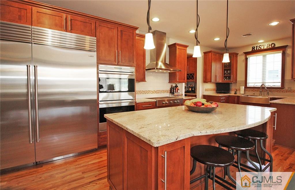 5 Timber Road Edison, NJ 08820 - Photo 11 of 24 a kitchen with stainless steel appliances kitchen island granite countertop a sink a refrigerator and chairs