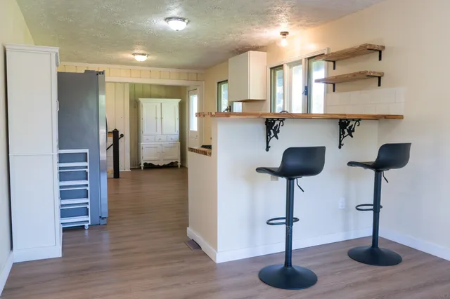 a kitchen with granite countertop a stove a sink and a refrigerator