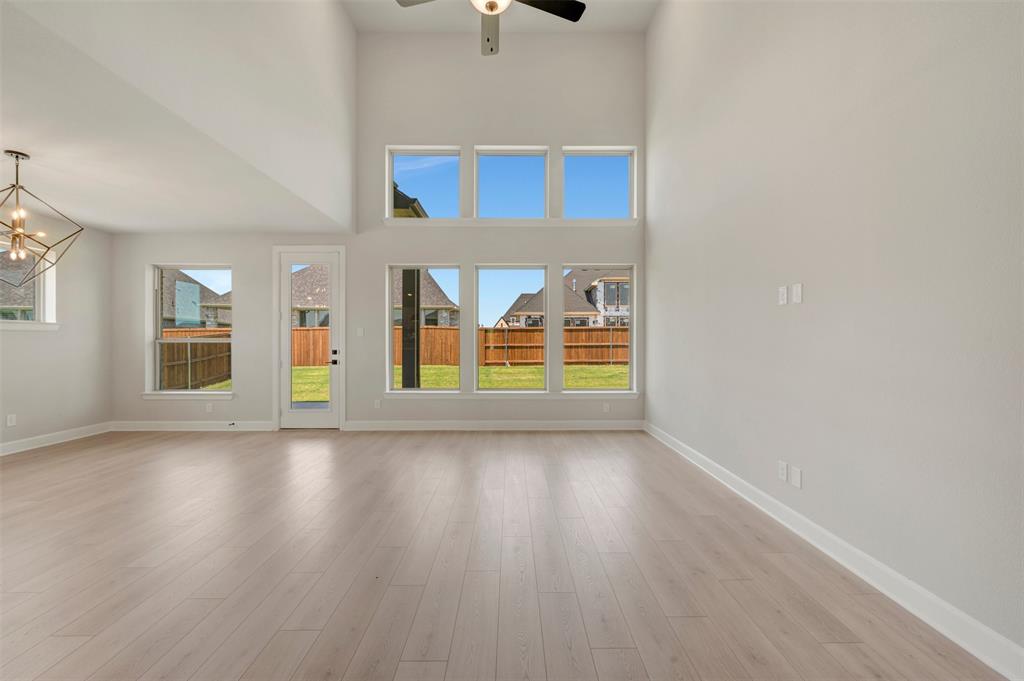 4308 Palomino Road Aubrey, TX 76227 - Photo 20 of 40 an empty room with wooden floor and windows