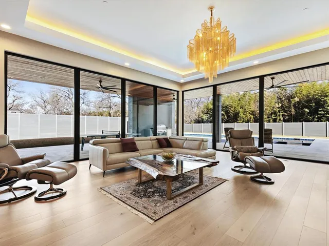 a large kitchen with kitchen island a large window a sink and stainless steel appliances