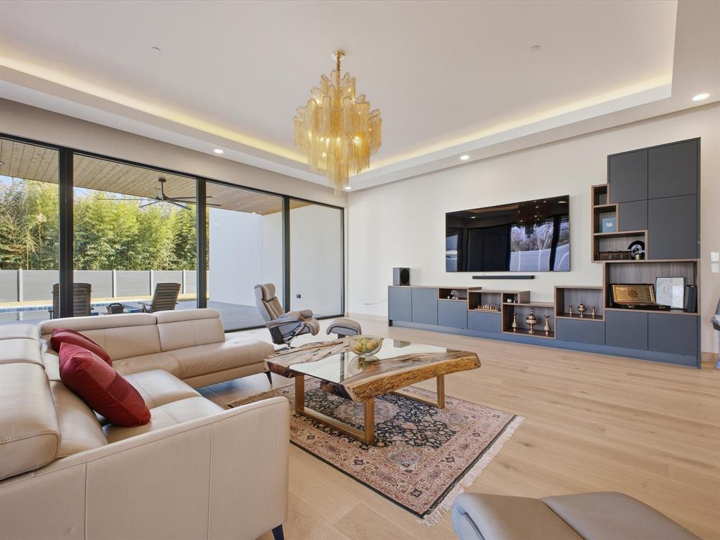 10230 Marsh Lane Dallas, TX 75229 - Photo 17 of 31 a living room with furniture a chandelier and a flat screen tv