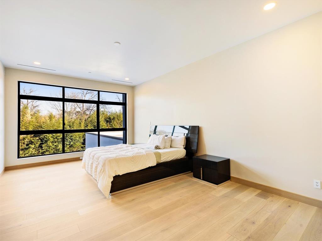 10230 Marsh Lane Dallas, TX 75229 - Photo 27 of 31 a large bed sitting in a room next to a lamp next to a window