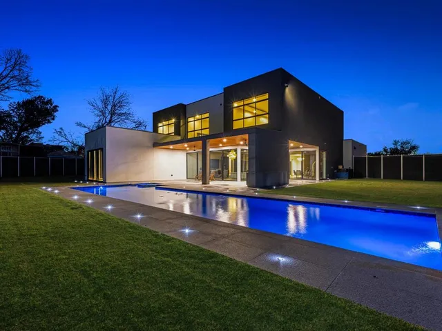 a view of swimming pool with lawn chairs and a potted plant