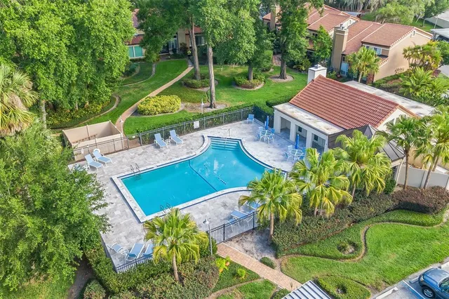 an aerial view of residential houses with outdoor space and trees