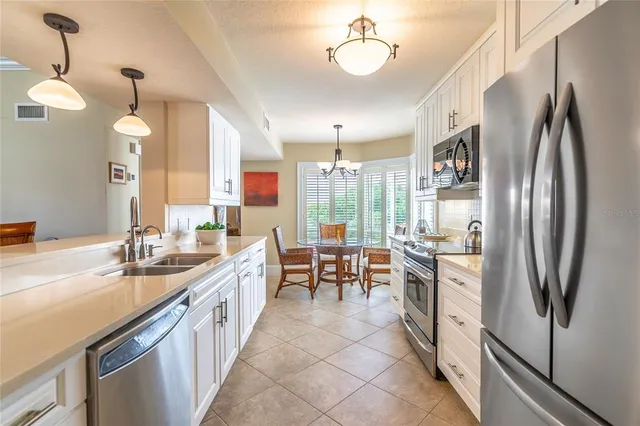 a kitchen with stainless steel appliances a sink stove and refrigerator