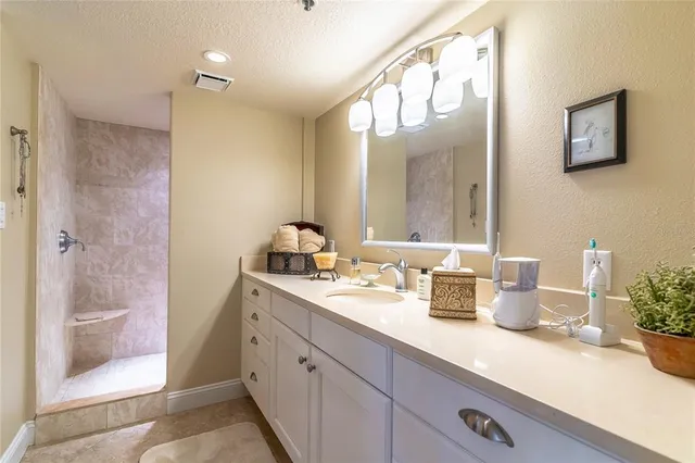 a bathroom with a double vanity sink mirror and shower