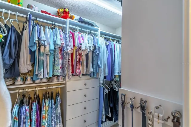 a view of walk in closet with clothes