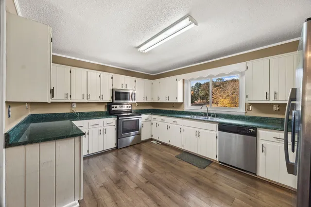 a kitchen with granite countertop white cabinets and sink