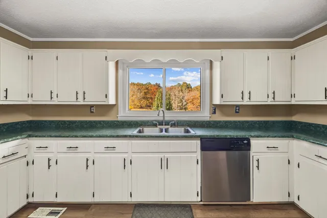 a kitchen with granite countertop white cabinets and stainless steel appliances
