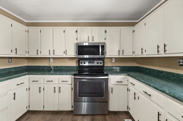 a kitchen with granite countertop a refrigerator and a sink