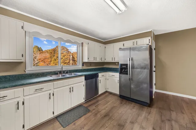 a kitchen with granite countertop white cabinets and stainless steel appliances
