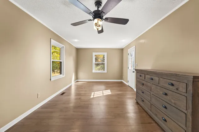 an empty room with window and ceiling fan