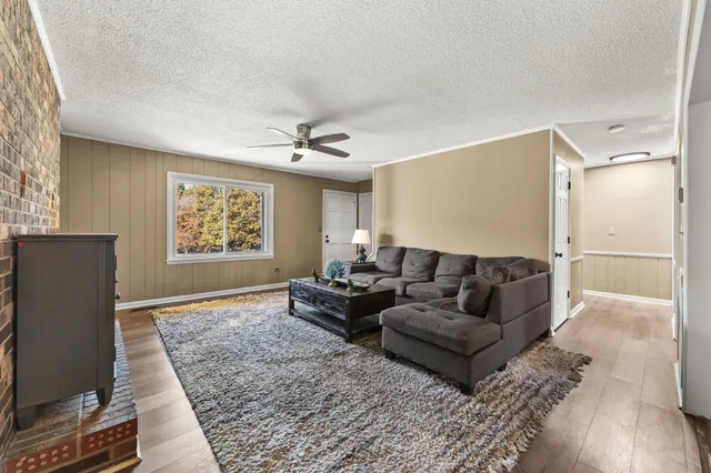 a living room with furniture a fireplace and wooden floor
