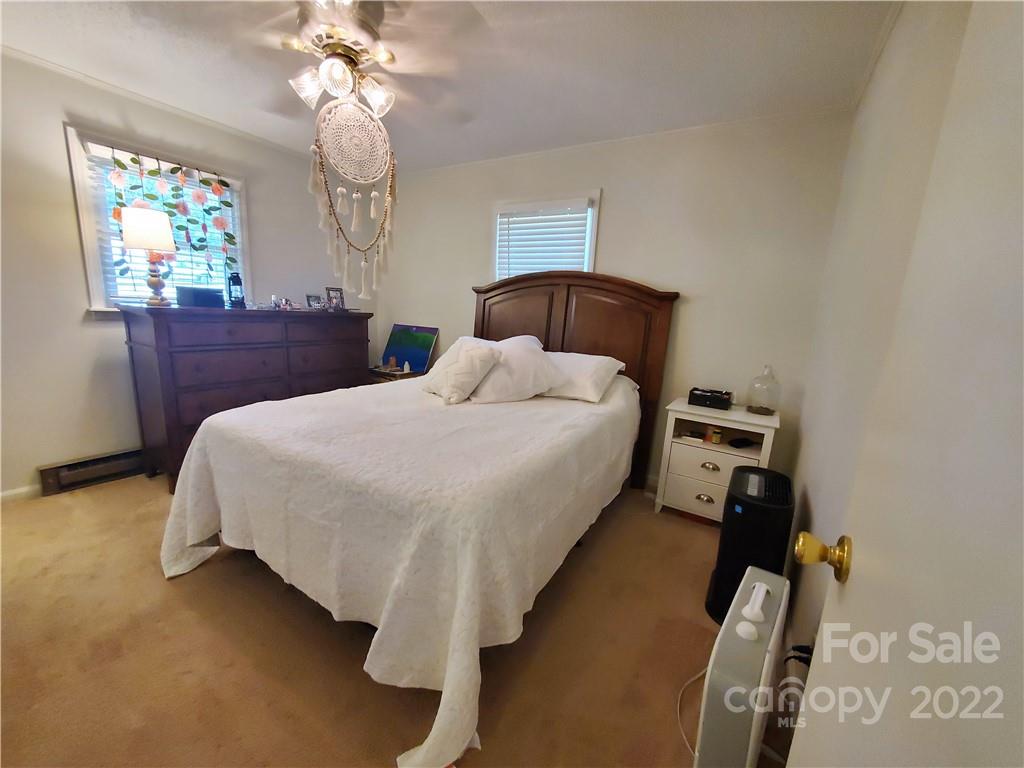 4681 Emerald Drive Morganton, NC 28655 - Photo 21 of 38 a bedroom with a bed and a chandelier