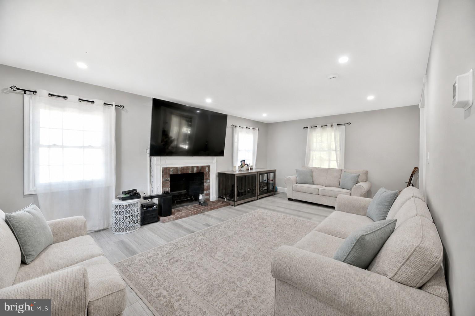 8812 Churchfield Lane Laurel, MD 20708 - Photo 16 of 31 a living room with furniture a fireplace and a flat screen tv
