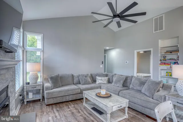 a kitchen with stainless steel appliances granite countertop a stove a sink dishwasher and white cabinets with wooden floor