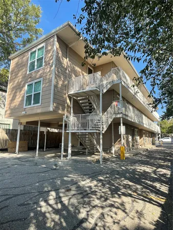 a front view of a house with large trees