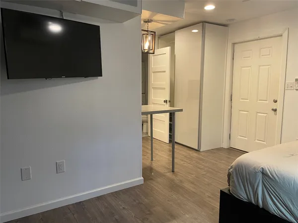 a spacious bedroom with a bed and a flat screen tv