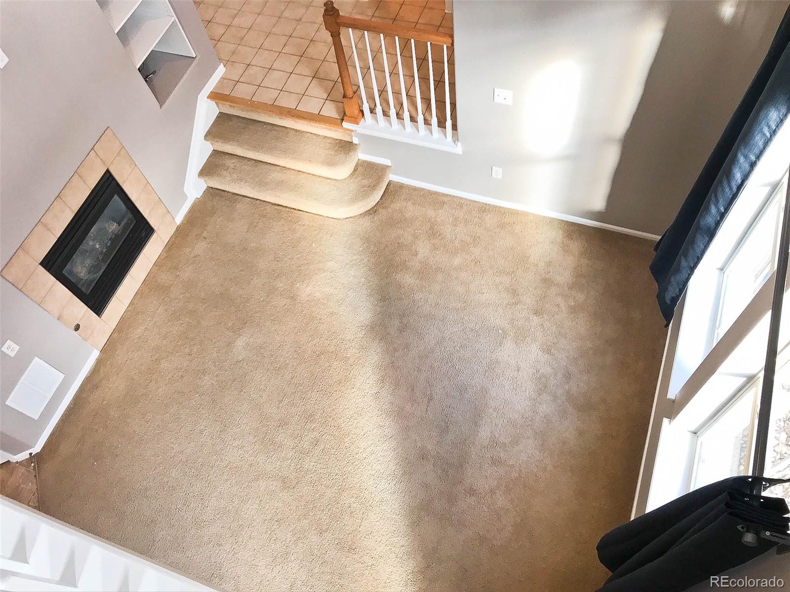 6753 South Winnipeg Circle, Unit 101 Aurora, CO 80016 - Photo 11 of 36 a view of an empty room with a fireplace and a window