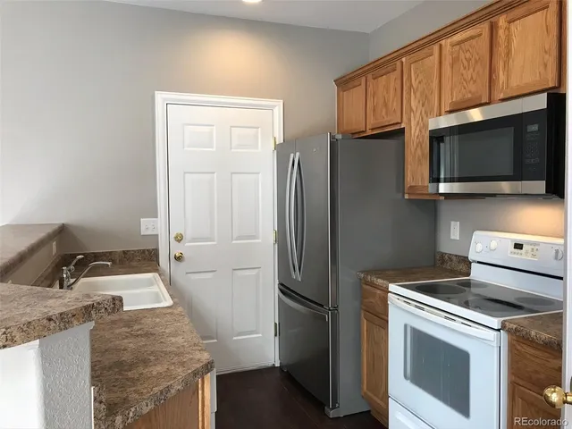 a kitchen with stainless steel appliances granite countertop a refrigerator stove and microwave