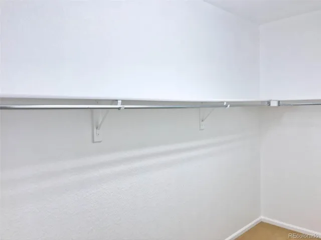 a view of a closet with racks on the wall