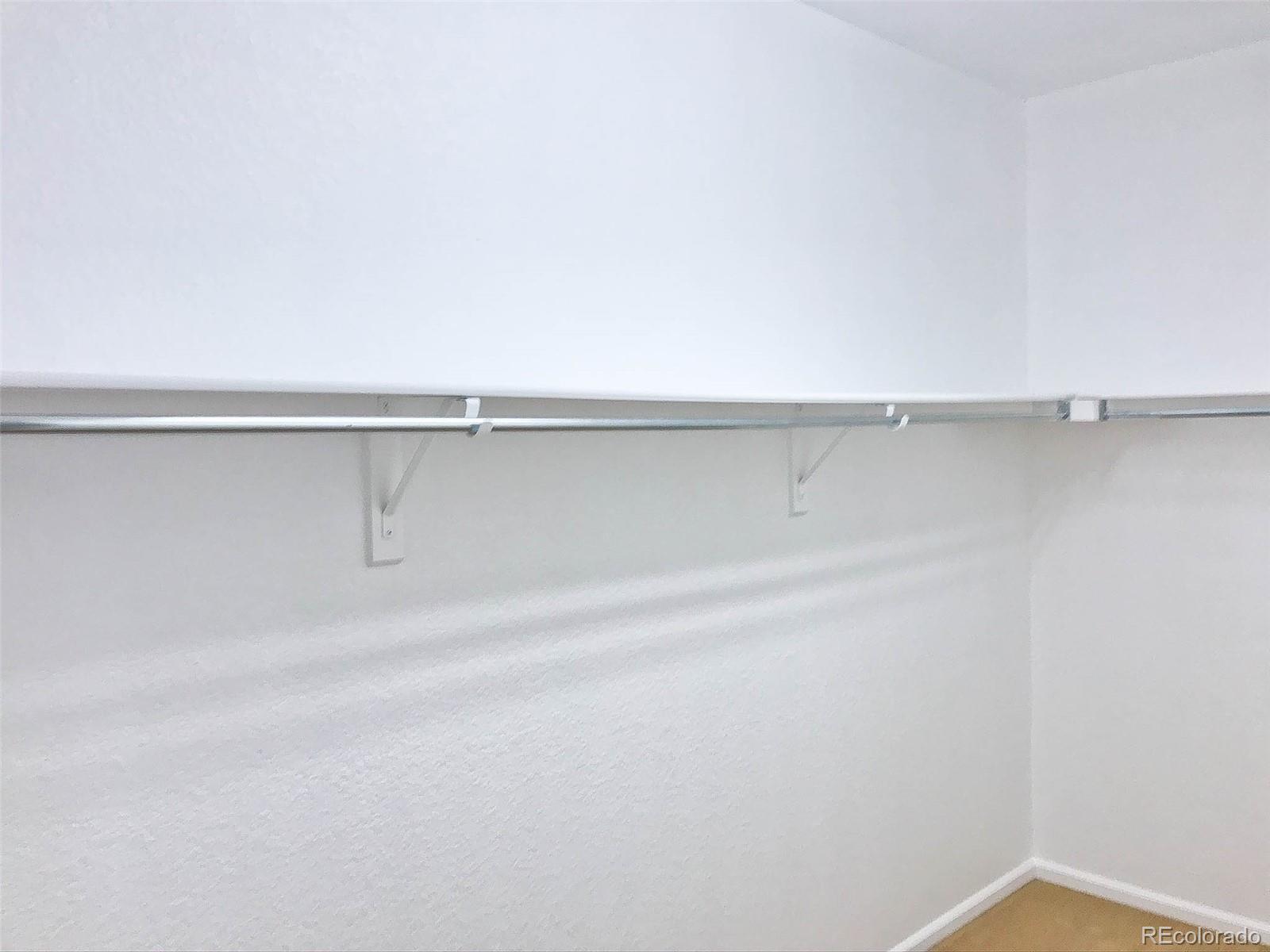 6753 South Winnipeg Circle, Unit 101 Aurora, CO 80016 - Photo 24 of 36 a view of a closet with racks on the wall