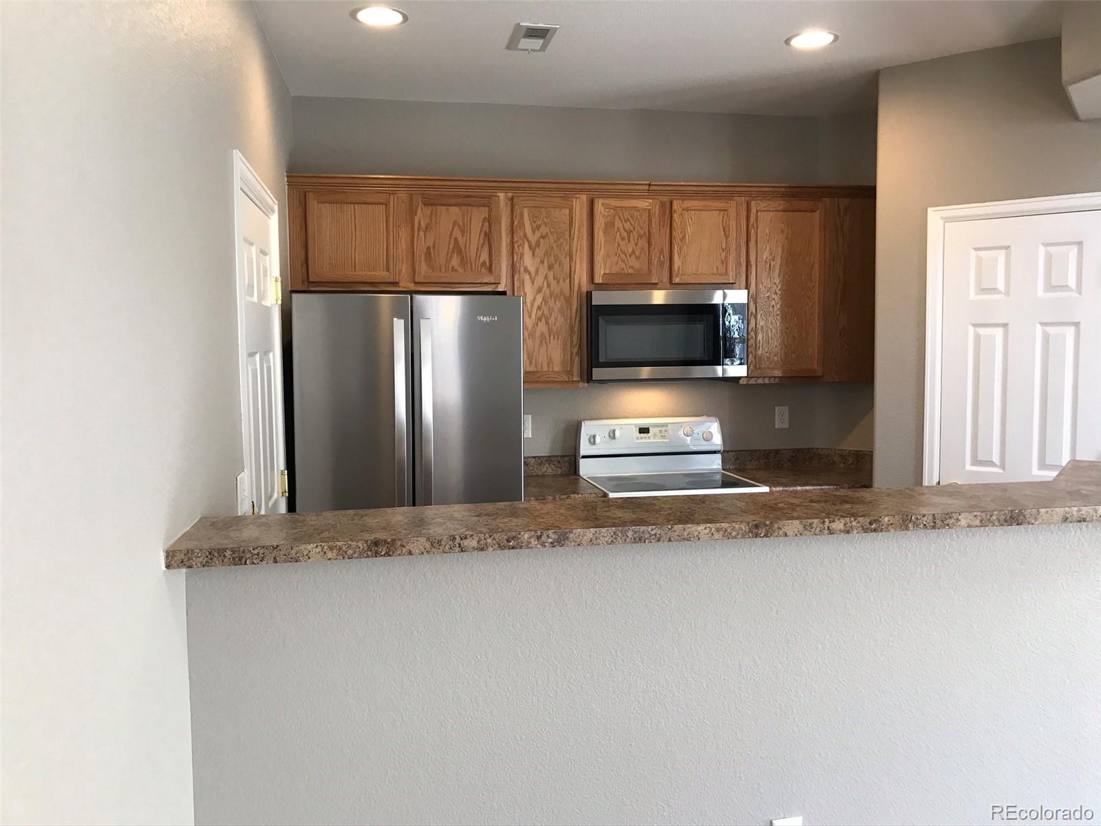 6753 South Winnipeg Circle, Unit 101 Aurora, CO 80016 - Photo 3 of 36 a view of a refrigerator a sink and a microwave