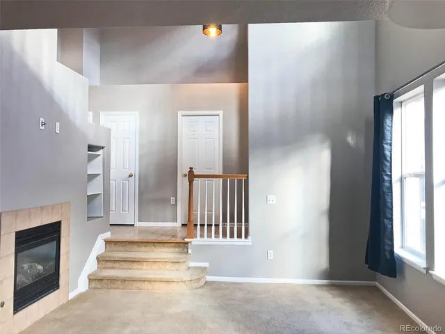 a view of an entryway with wooden floor and a fireplace