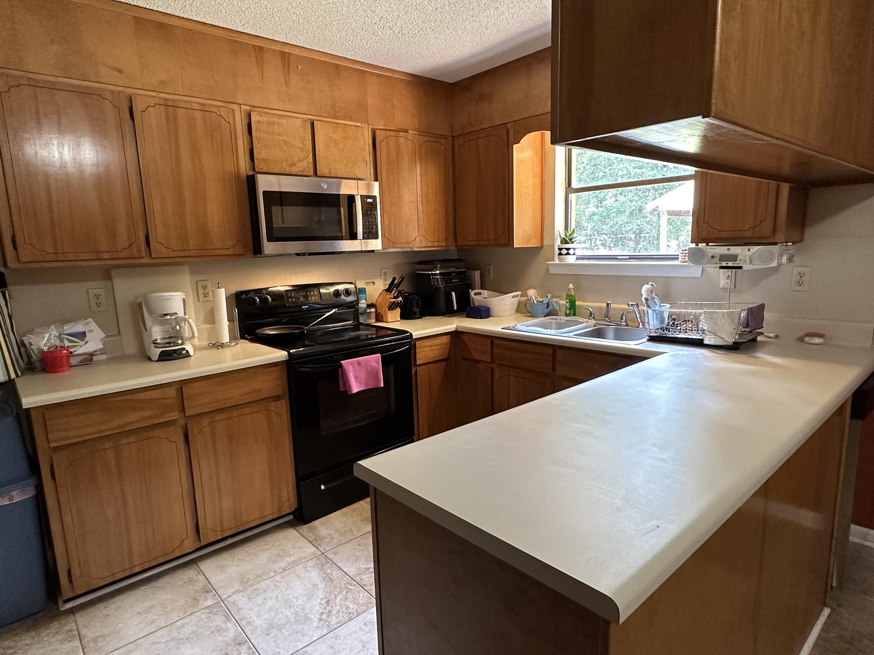 4872 Griffith Mill Road Holt, FL 32564 - Photo 5 of 15 a kitchen with stainless steel appliances a sink a stove a microwave a sink a refrigerator and cabinets
