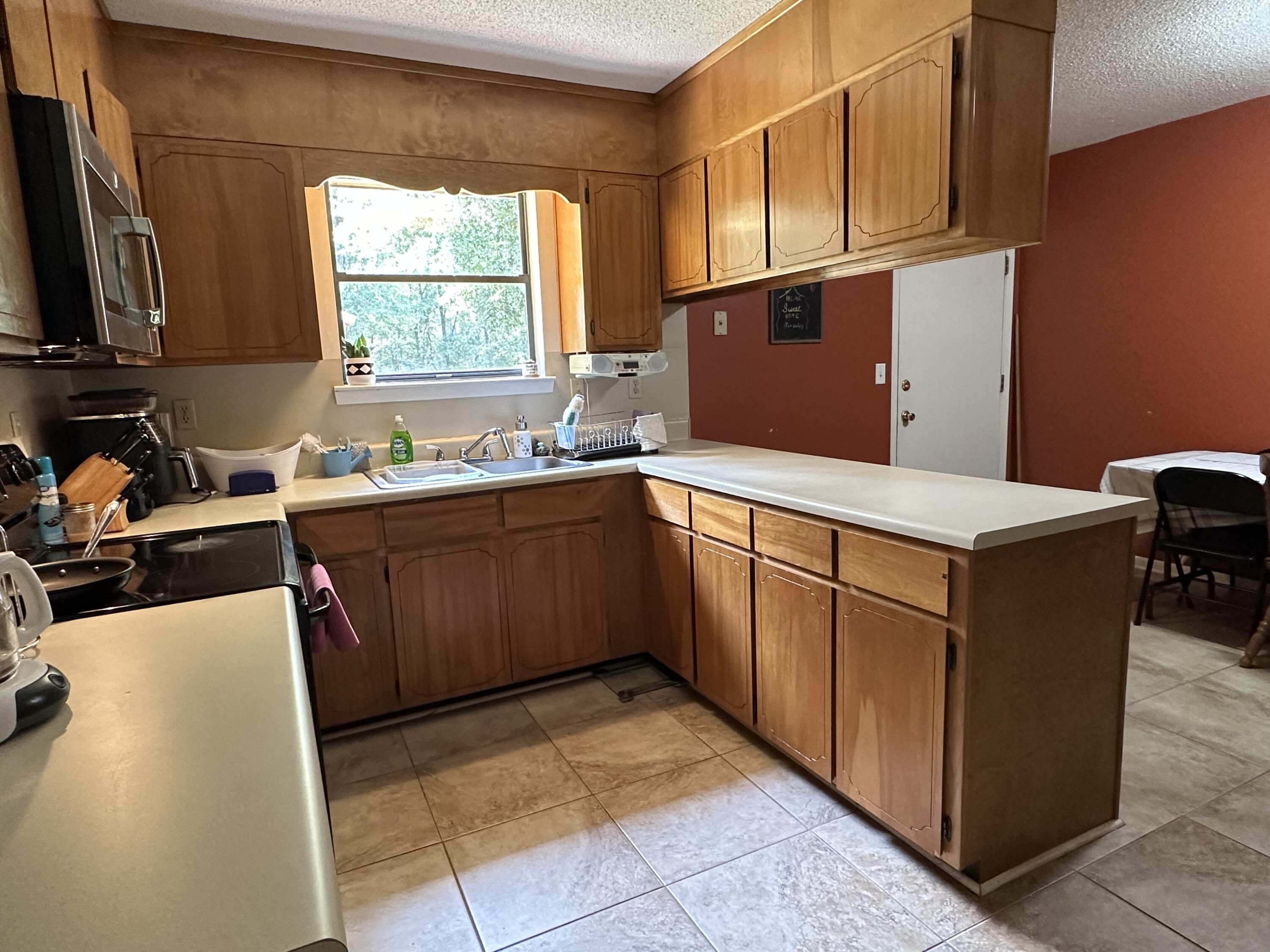 4872 Griffith Mill Road Holt, FL 32564 - Photo 6 of 15 a kitchen with stainless steel appliances granite countertop a sink counter space and a window