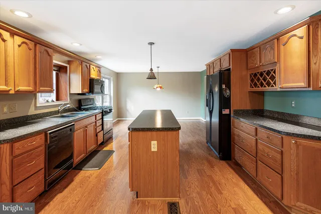 a kitchen with stainless steel appliances granite countertop a sink a stove top oven a counter space and cabinets