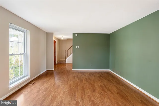 a view of a big room with wooden floor and windows