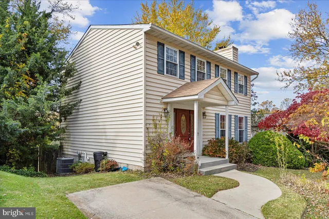 a view of a white house with a yard and potted plants