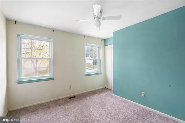 an empty room with a ceiling fan and a window