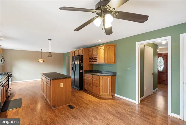 a kitchen with stainless steel appliances granite countertop a refrigerator a sink and a stove