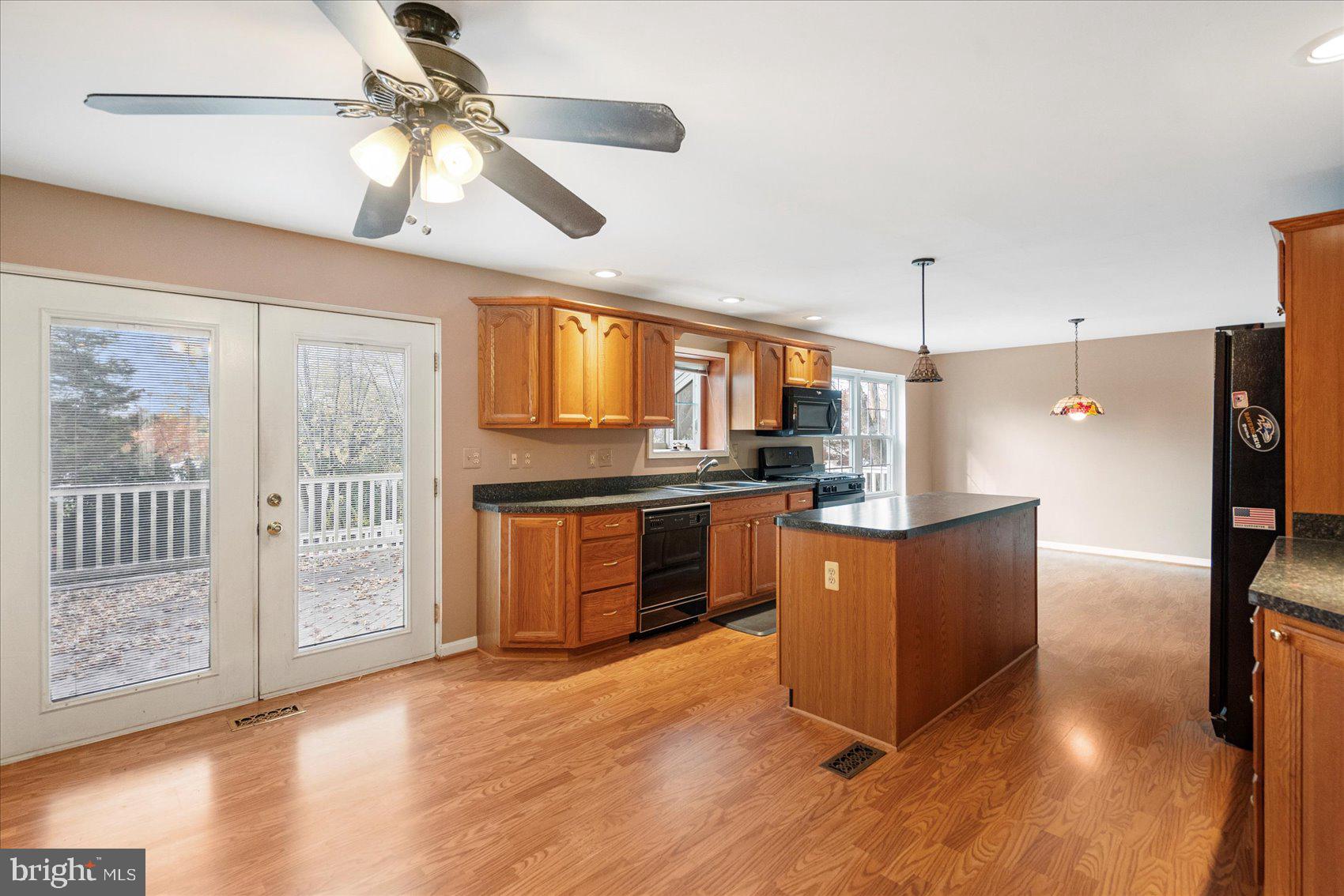 4003 Jacinth Way Baltimore, MD 21236 - Photo 10 of 43 a kitchen with stainless steel appliances granite countertop a refrigerator a sink dishwasher a stove and a dining table with wooden floor