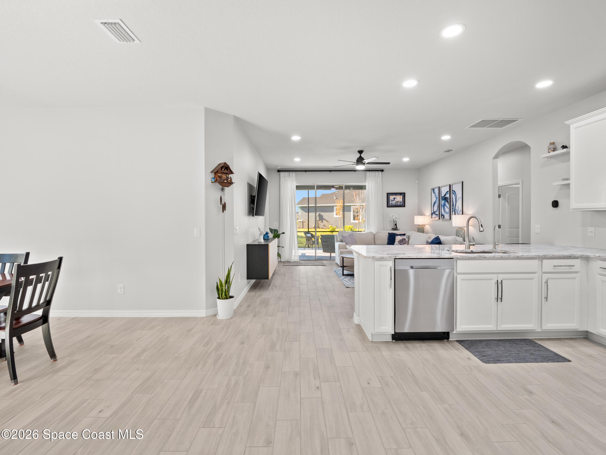 3363 Addison Drive Melbourne, FL 32940 - Photo 12 of 53 a large white kitchen with a white countertops a stove a dining table and chairs