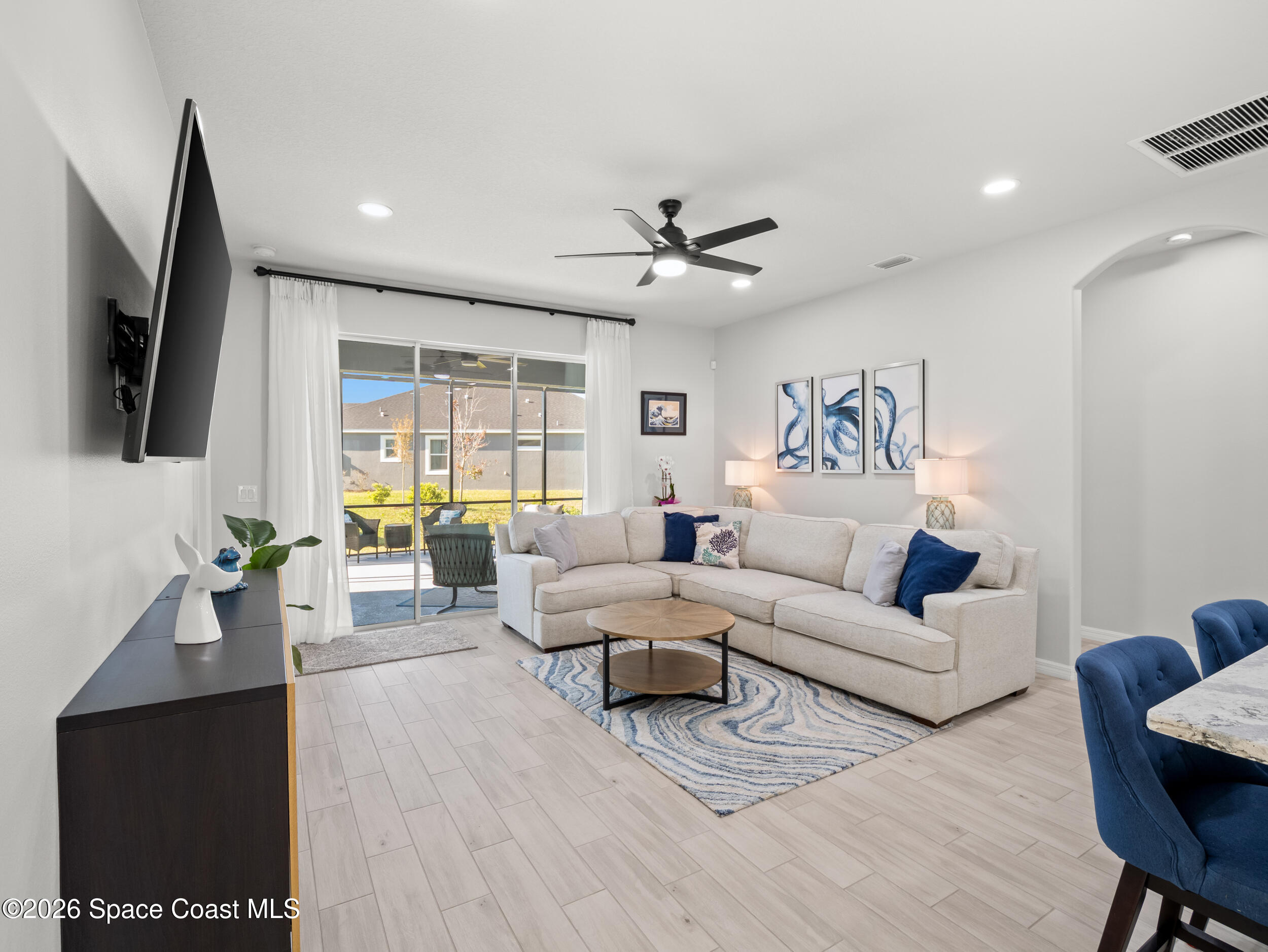 3363 Addison Drive Melbourne, FL 32940 - Photo 14 of 53 a living room with furniture a large window and a flat screen tv
